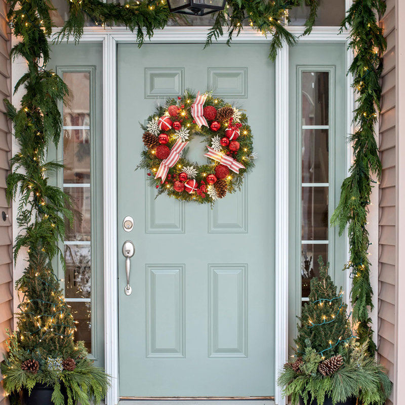 24" Pre-Lit Pine Christmas Wreath hanging on a front door