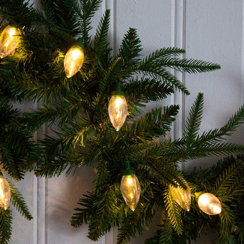 6 ft Gold Pre-Lit Ball Christmas Garland wrapped around a staircase banister