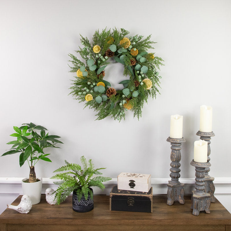 24" Pre-Lit Artificial Pine Christmas Wreath hung on a wooden door