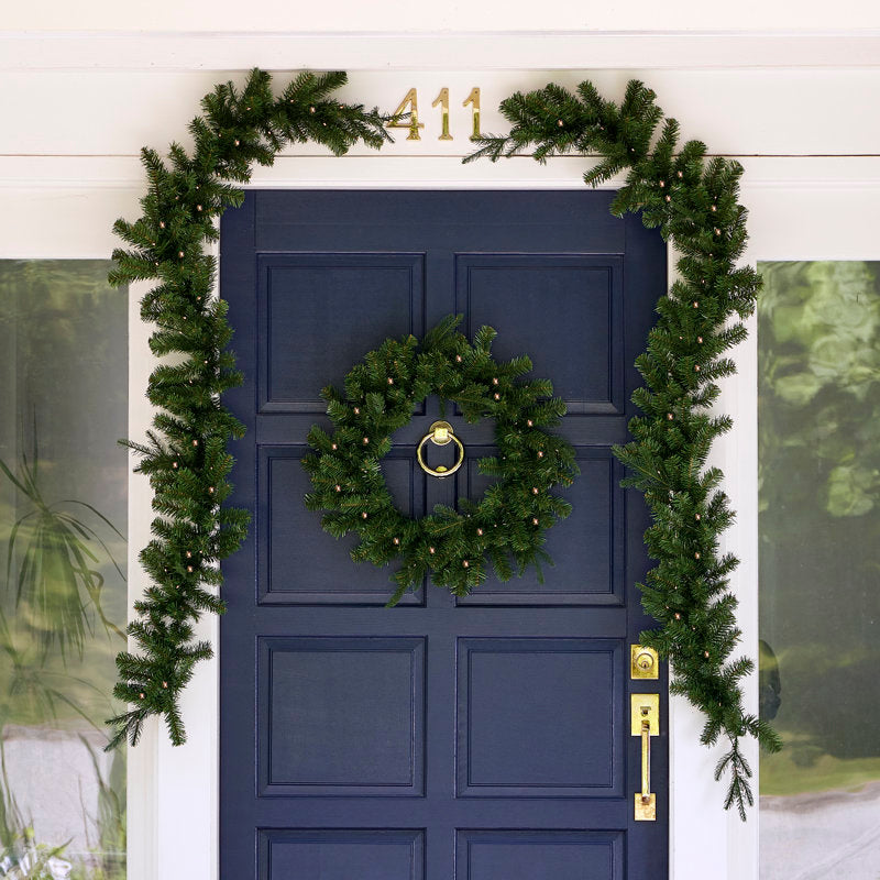 24" Pre-Lit Artificial Pine Christmas Wreath hung on a wooden door