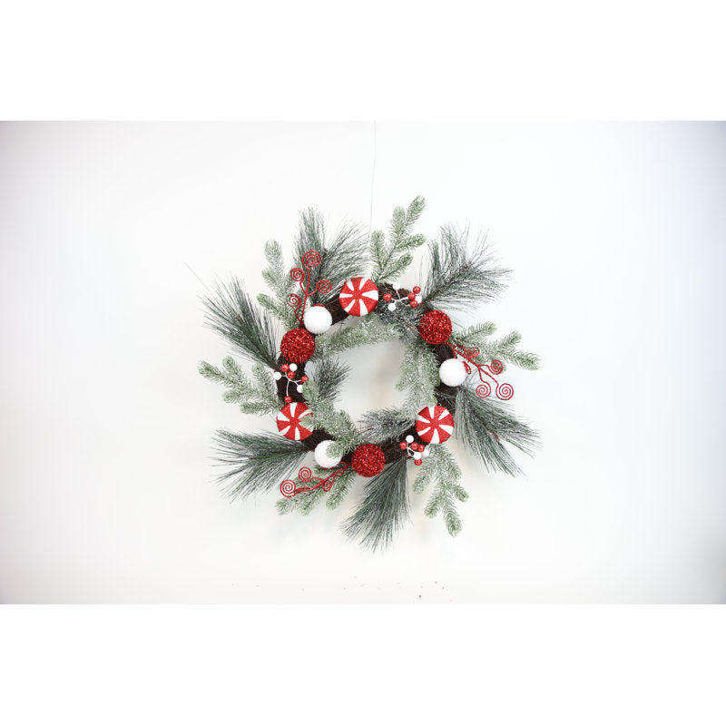 24" Artificial Pine Christmas Wreath hung on a wooden door