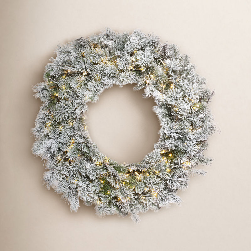 Flocked Artificial Pine Christmas Wreath hung on a wooden door